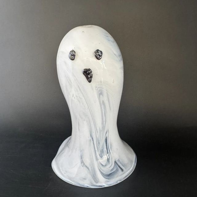 White swirled glass ghost with dark glass eyes and mouth.